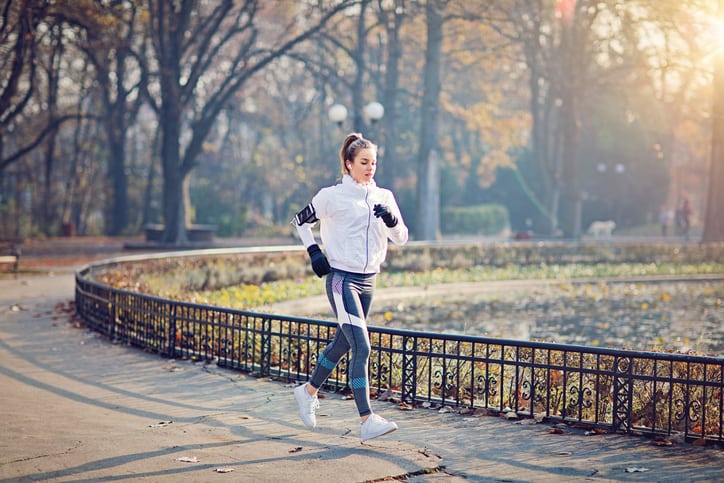 Young woman is running in the cold autumn morning